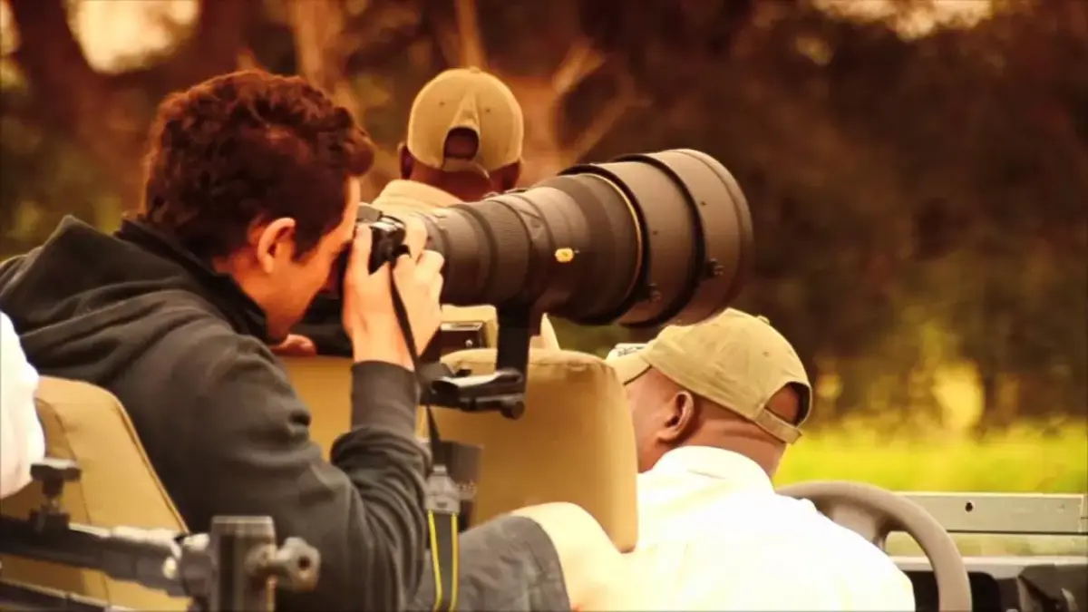 Photographers with long lenses in a safari vehicle